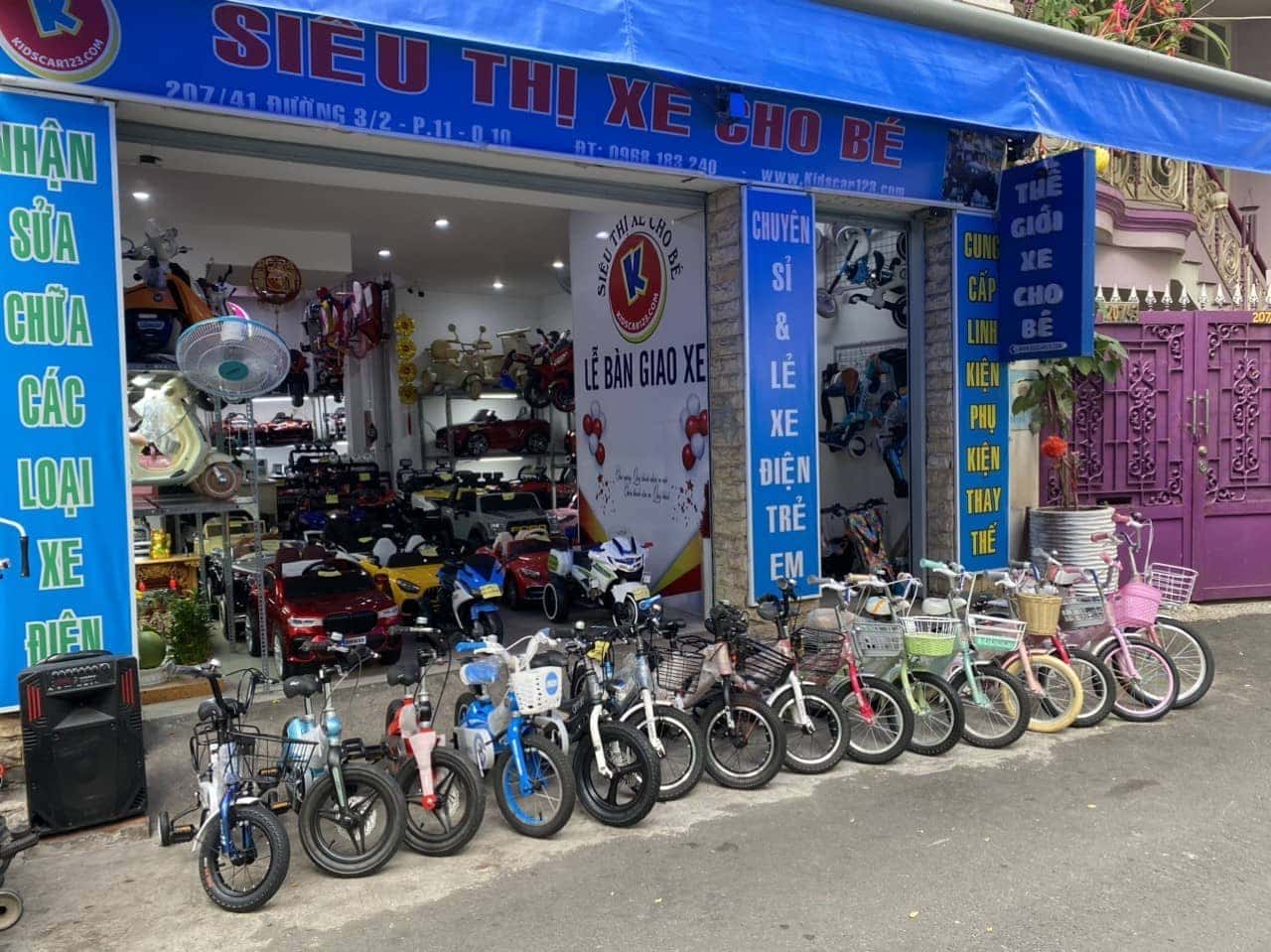 Bé gái ngồi thử chiếc xe trẻ em 3 bánh màu hồng xinh xắn