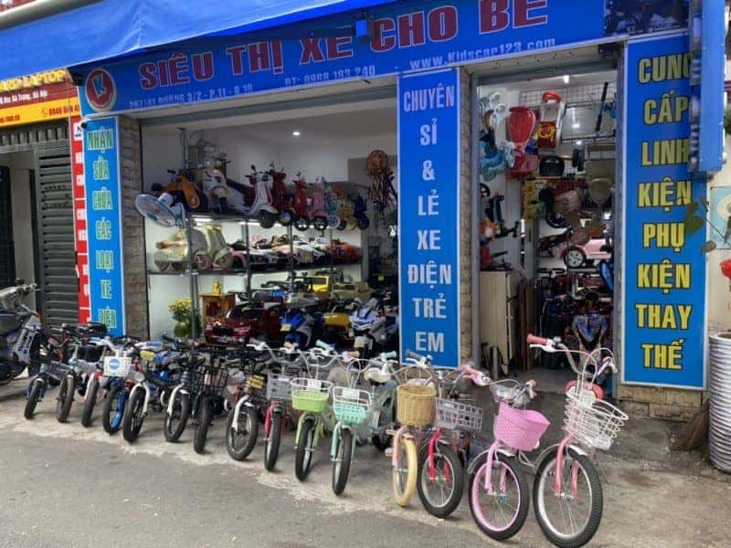 Bé trai vui vẻ khám phá xe trẻ em 3 bánh ngoài trời