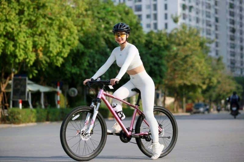 Cô gái trẻ đạp xe thể thao giúp tăng cường sức khỏe tim mạch và phát triển cơ bắp