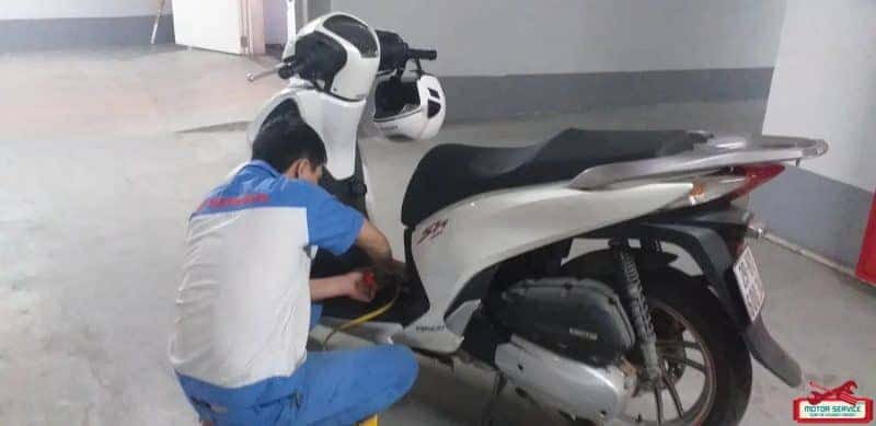 Kỹ thuật viên đang sửa xe máy bị hỏng tại chỗ