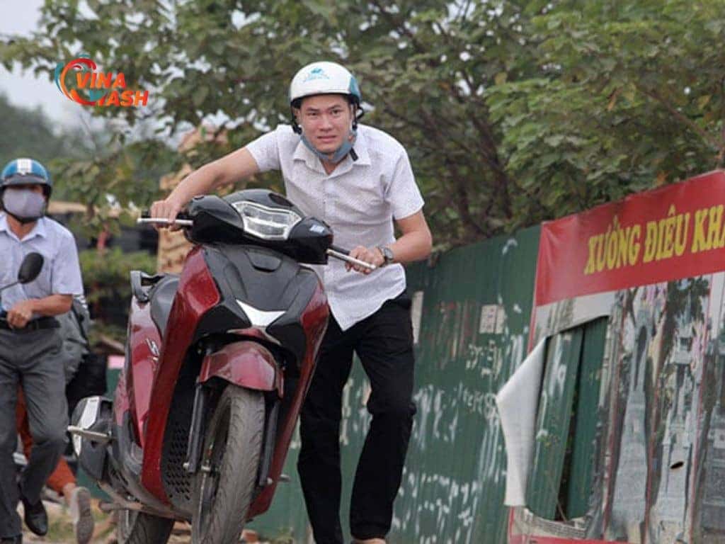 Người lái đang khởi động xe tay ga bị khó nổ lúc máy nguội, minh họa cách xử lý tình trạng này.