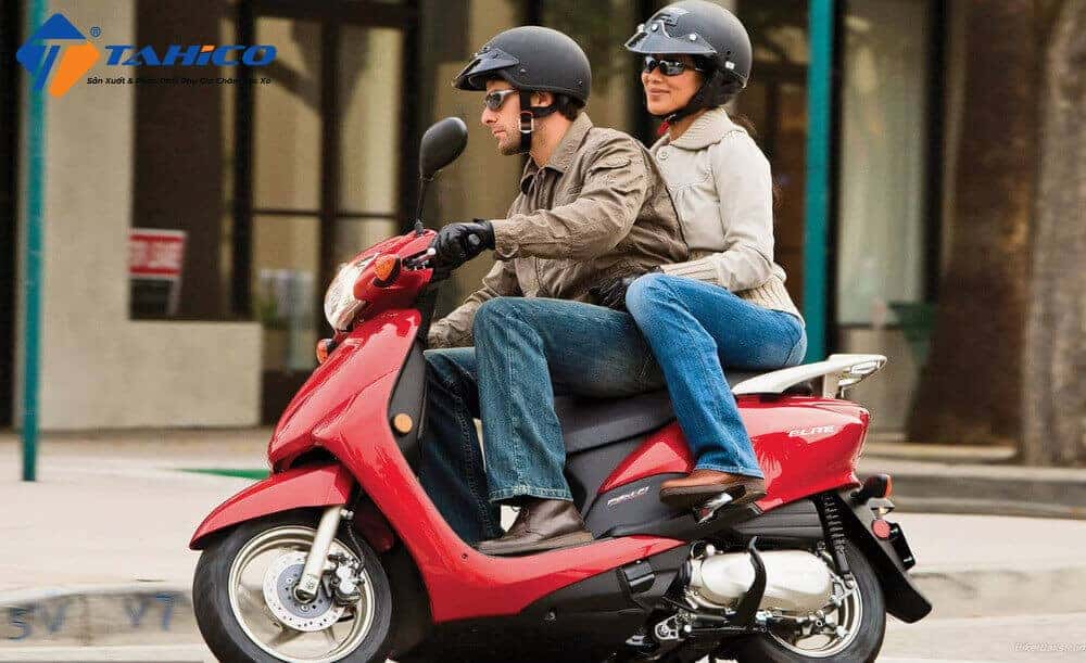 Người thợ đang kiểm tra mức dầu nhớt động cơ xe máy Honda, hướng dẫn lịch trình thay nhớt định kỳ.