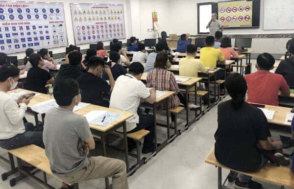 Phòng học lý thuyết lái xe B2 tại trung tâm với học viên đang lắng nghe giáo viên