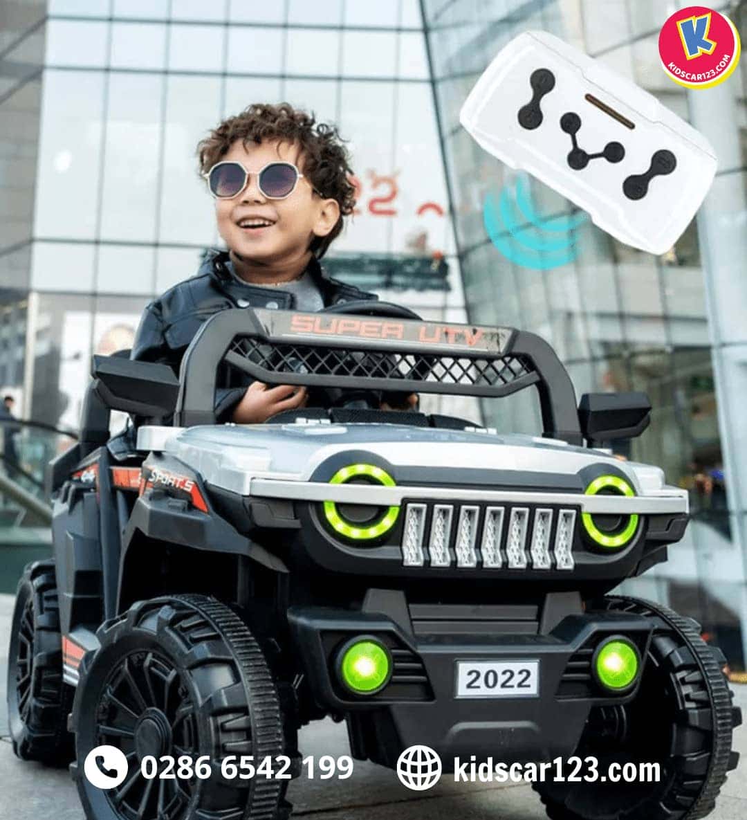 Bé trai ngồi trên xe điện cho em bé màu trắng có điều khiển