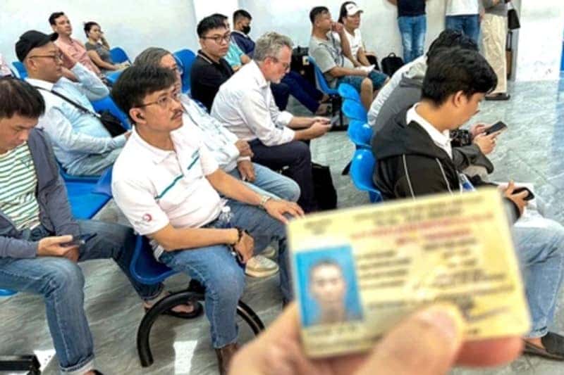 Người đàn ông cầm bằng lái xe và các giấy tờ tùy thân