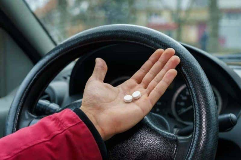Người phụ nữ cầm viên thuốc say xe, biểu tượng cho hiệu quả thuốc say xe