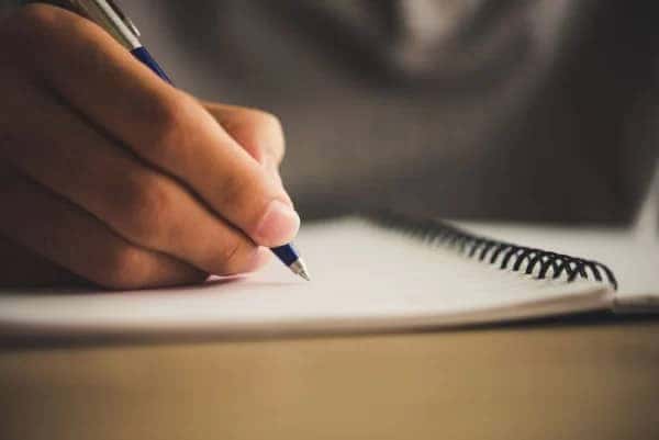Bàn tay đang ghi chép thông tin về biển số xe, minh họa việc tìm hiểu biển số xe tiếng Anh