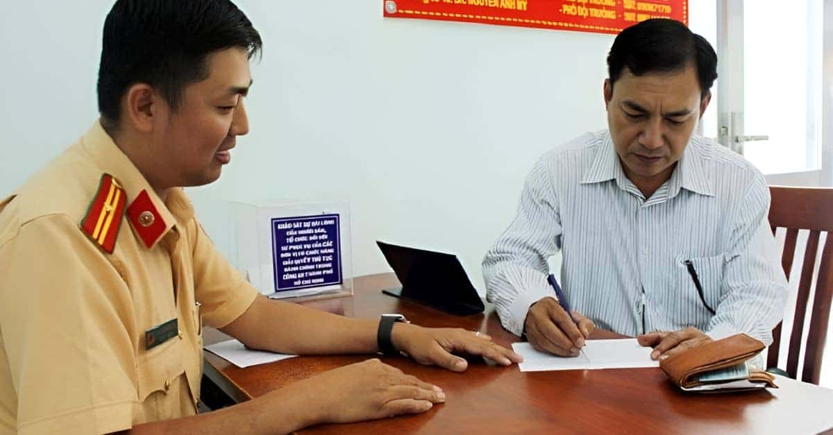 Cán bộ kiểm tra đối chiếu thông tin đăng ký biển số xe