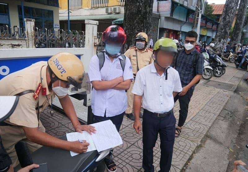 Cảnh sát giao thông kiểm tra giấy tờ người lái xe máy chưa đủ tuổi