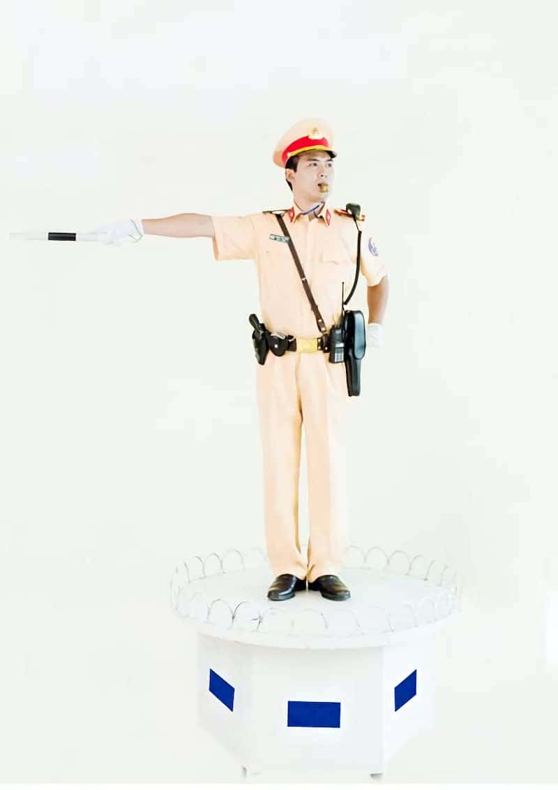 Cảnh sát giao thông ra hiệu lệnh giảm tốc độ bằng tay ngang thắt lưng