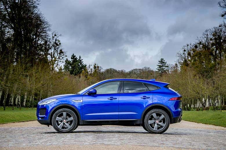 Jaguar E-PACE màu trắng đậu trên đường, nổi bật với thiết kế SUV thể thao và nhỏ gọn