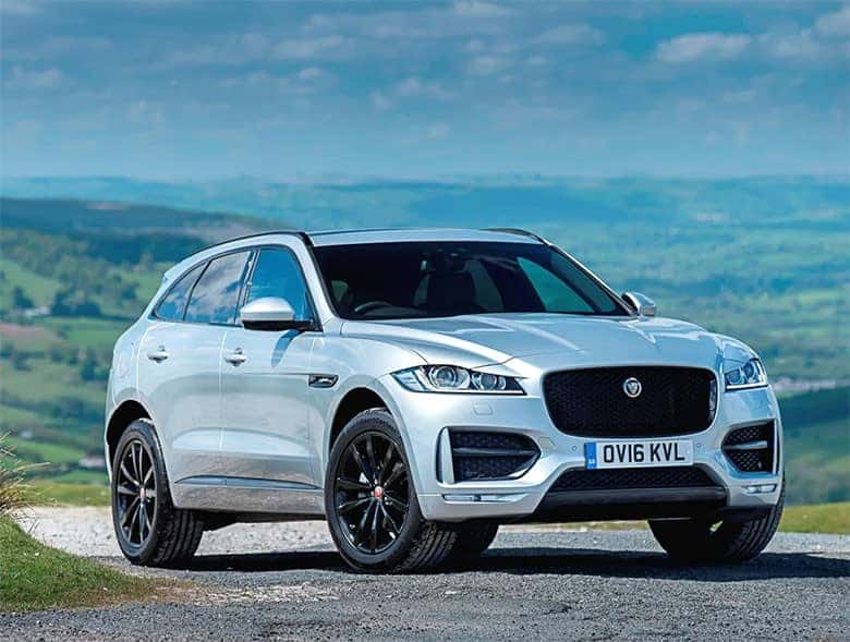 Jaguar F-PACE màu xanh đậu trên bãi cỏ, thể hiện sự mạnh mẽ và thể thao của dòng SUV hạng sang
