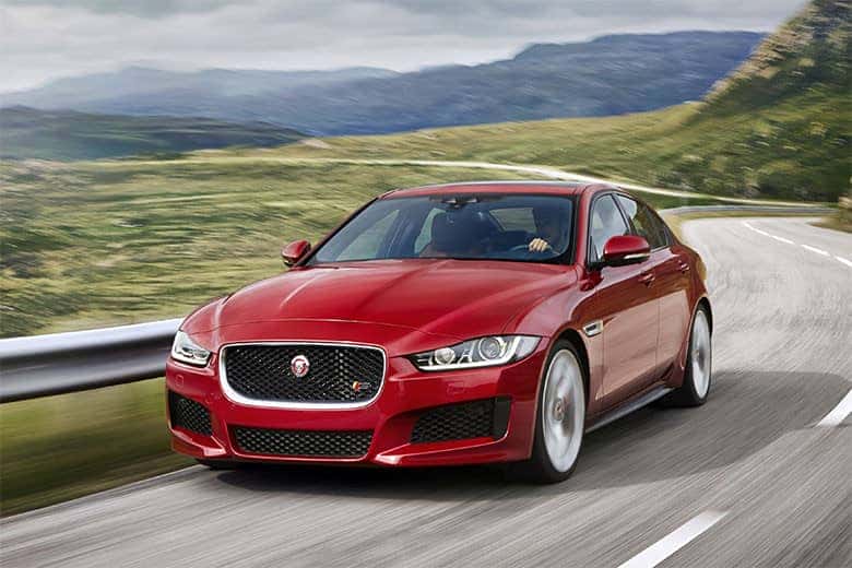 Jaguar XE màu đỏ đậu trên đường, thể hiện sự thể thao và sang trọng của mẫu sedan hạng sang