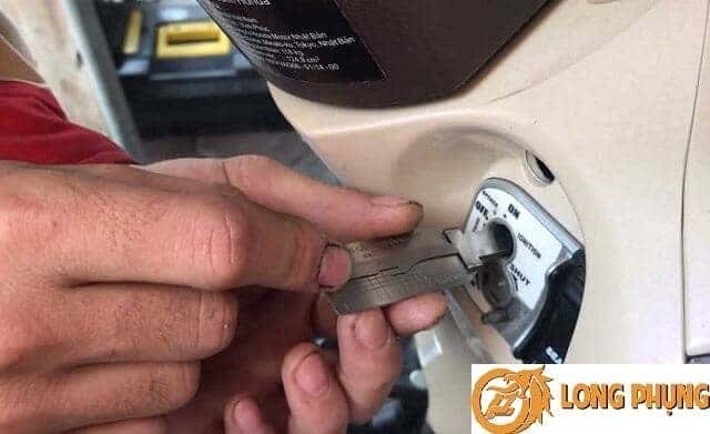 Thợ sửa xe đang kiểm tra ổ khóa xe máy, hỗ trợ khắc phục tình trạng mất chìa khóa xe Wave.