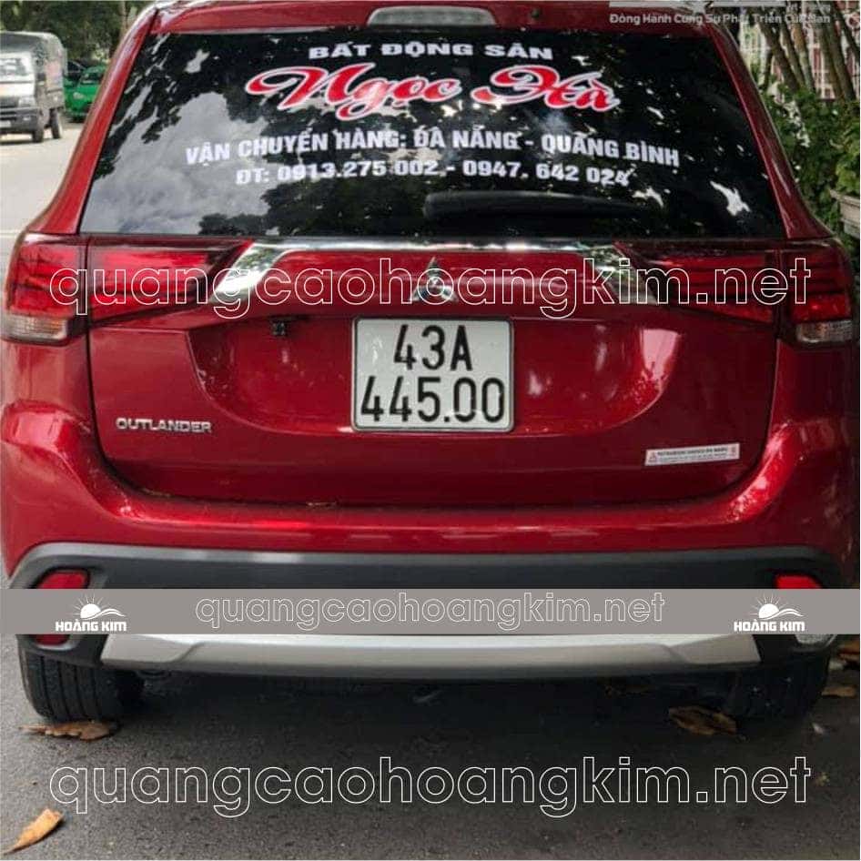 Xe du lịch màu trắng được dán đề can quảng cáo lớn ở bên hông
