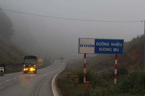 Xe ô tô di chuyển trong điều kiện sương mù dày đặc với đèn sương mù bật sáng, tăng cường khả năng nhìn rõ